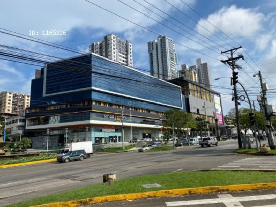 Shopping complex with glass storefronts and high-rise towers behind in Dorado City Center Panama