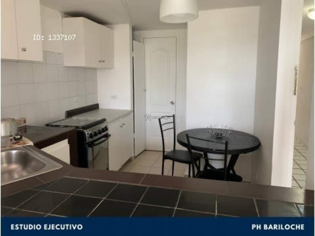 Compact kitchenette with fridge and stove in furnished studio PH Bariloche El Cangrejo Panama
