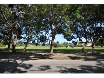 Large green vacant land with mature trees adjacent to a lake inside Buenaventura luxury resort Panama