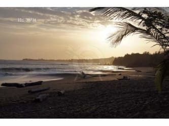 Two-story yellow beachfront home with balconies, garden tropical setting Pedasí Panama